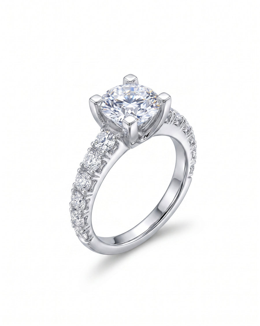 Silver fishtail set engagement ring with a cushion-cut center diamond and pavé band.