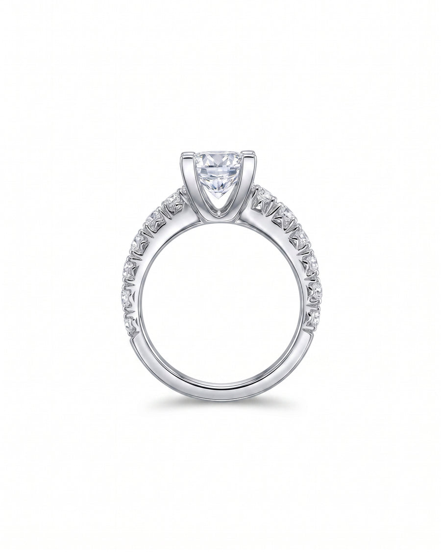Silver fishtail set engagement ring with a large center diamond and pave diamonds on the band.