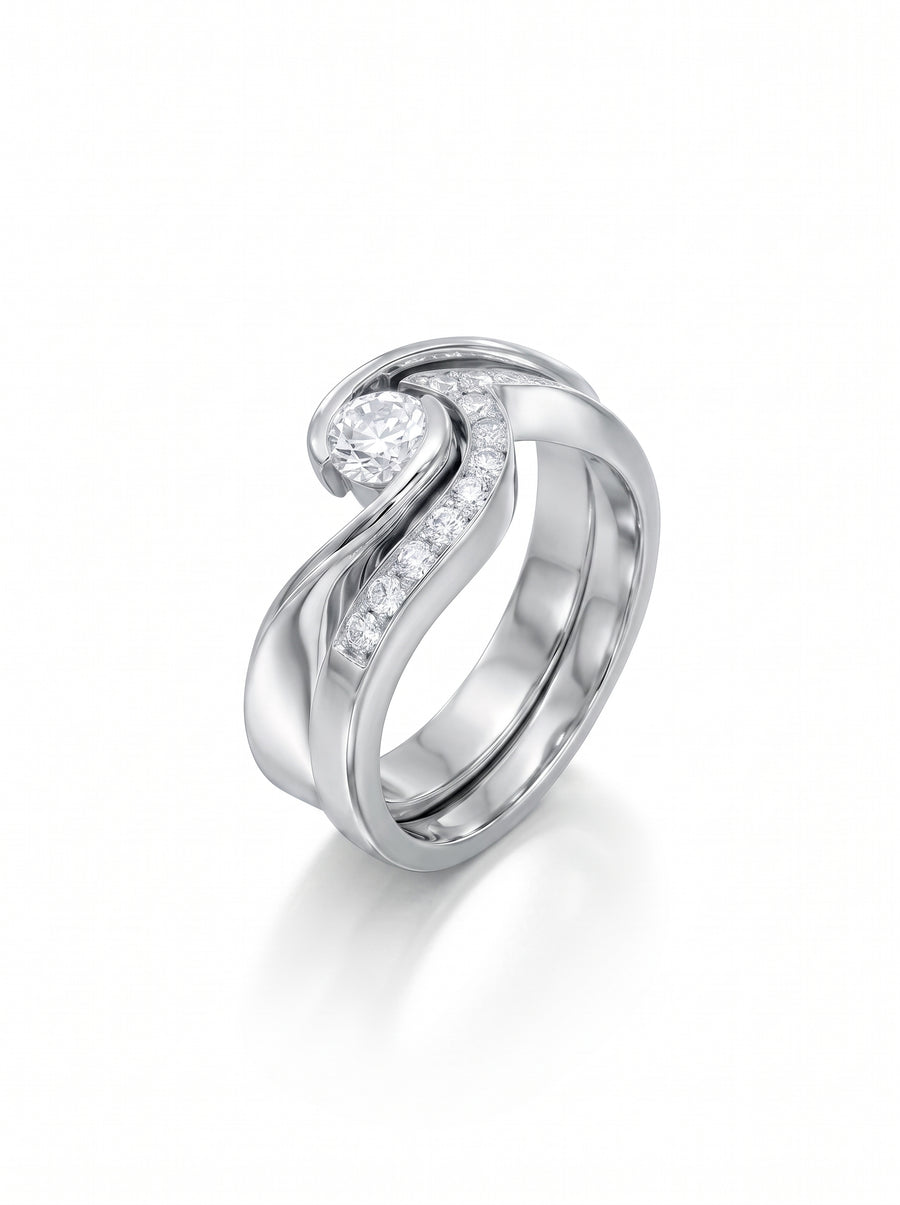 White gold engagement and wedding ring set with a round center diamond and channel-set accent stones.