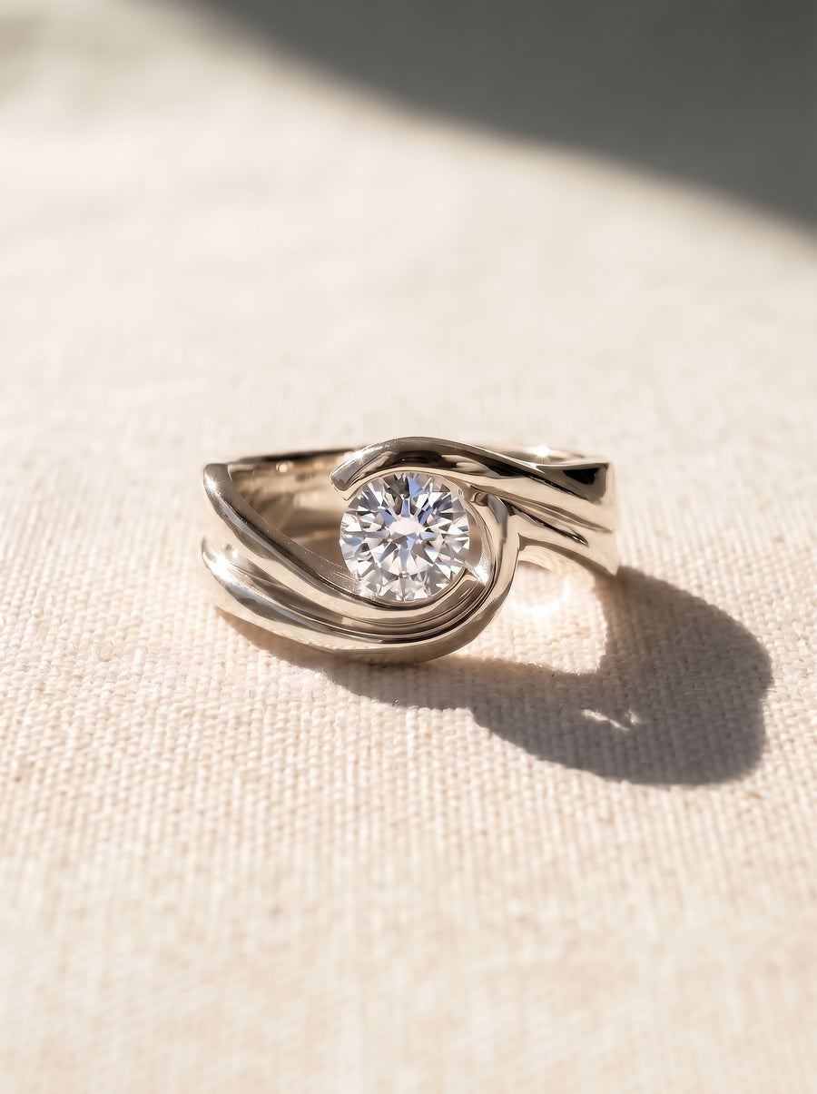 9ct white gold engagement ring with a round brilliant cut diamond in a flat twist bypass setting.