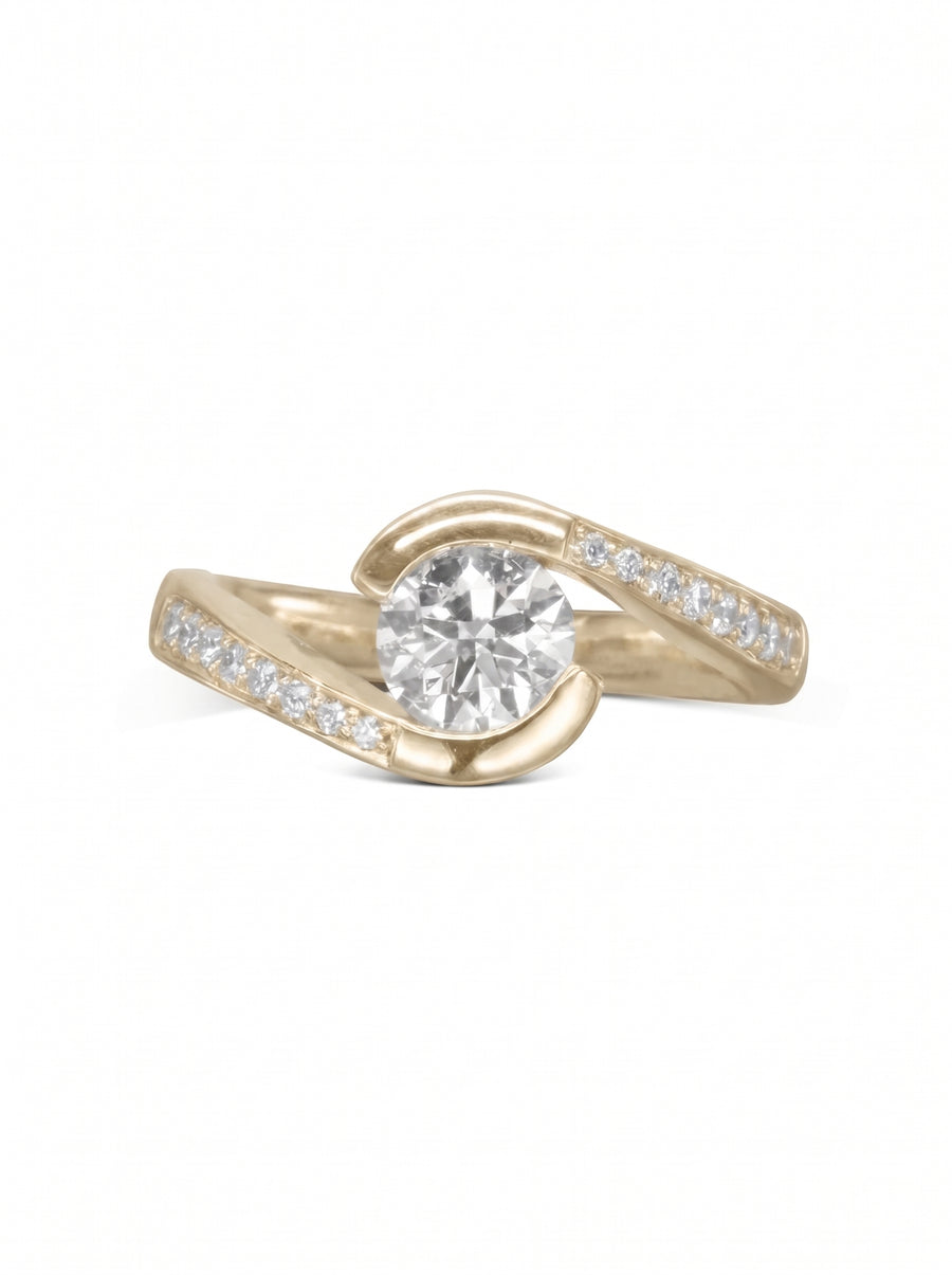 Yellow gold engagement ring with a round center diamond and pavé-set side stones in a flat twist design.