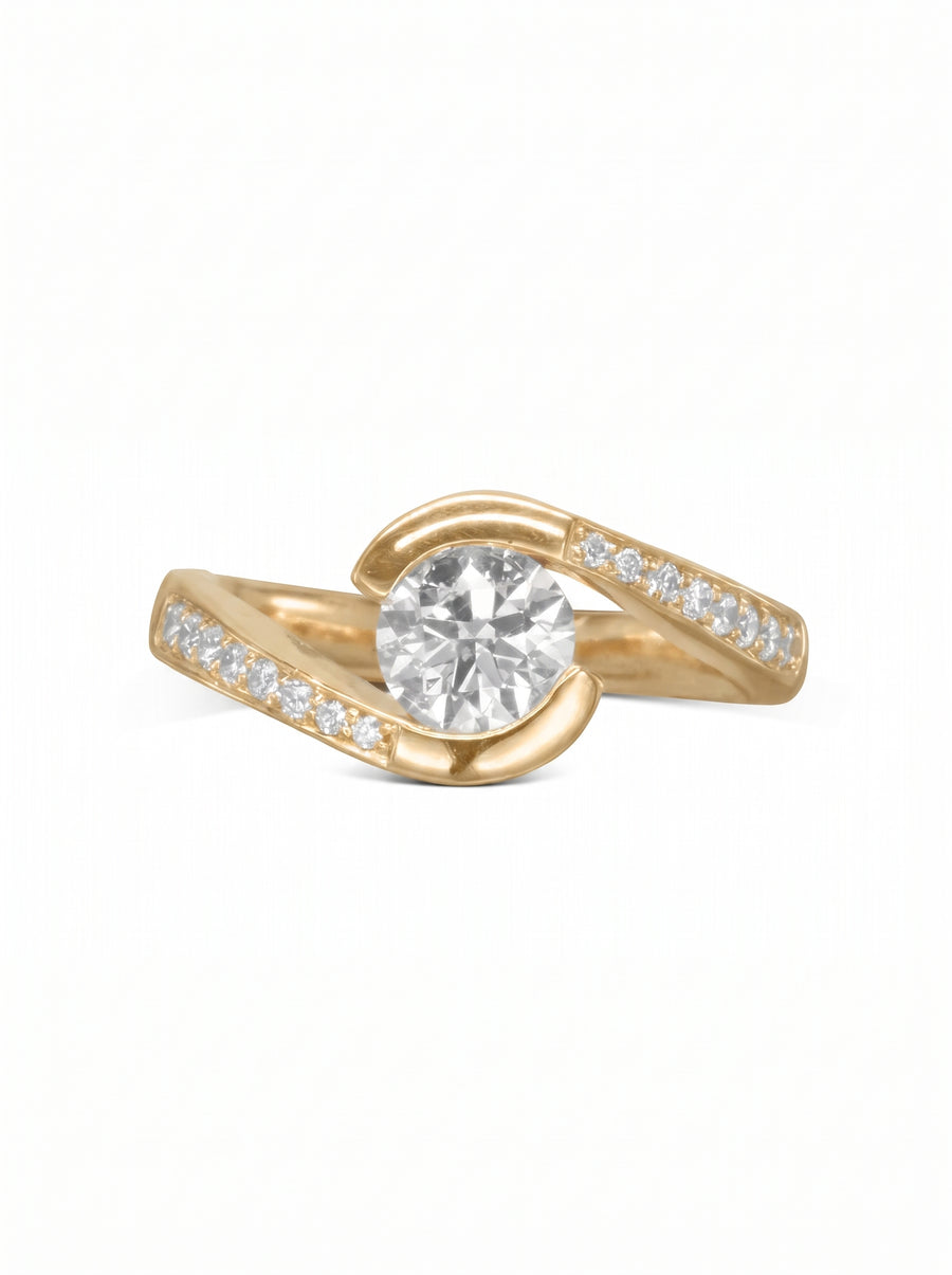 Yellow gold engagement ring with a round center diamond and pavé-set side stones in a flat twist design.