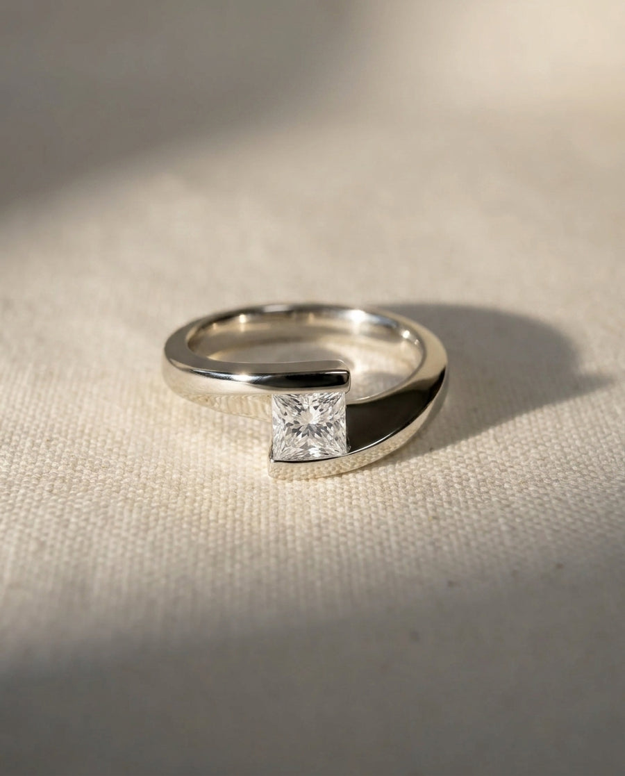 Platinum flat twist engagement ring with a princess cut diamond.