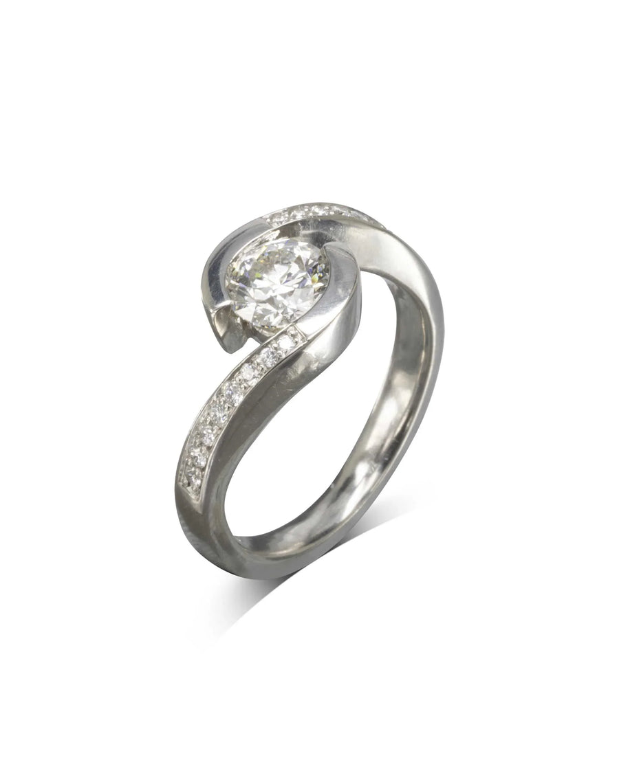 Yellow gold flat twist engagement ring with a round diamond and pave accents.