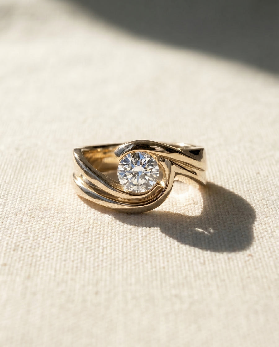 Yellow gold flat twist engagement ring with a round diamond.