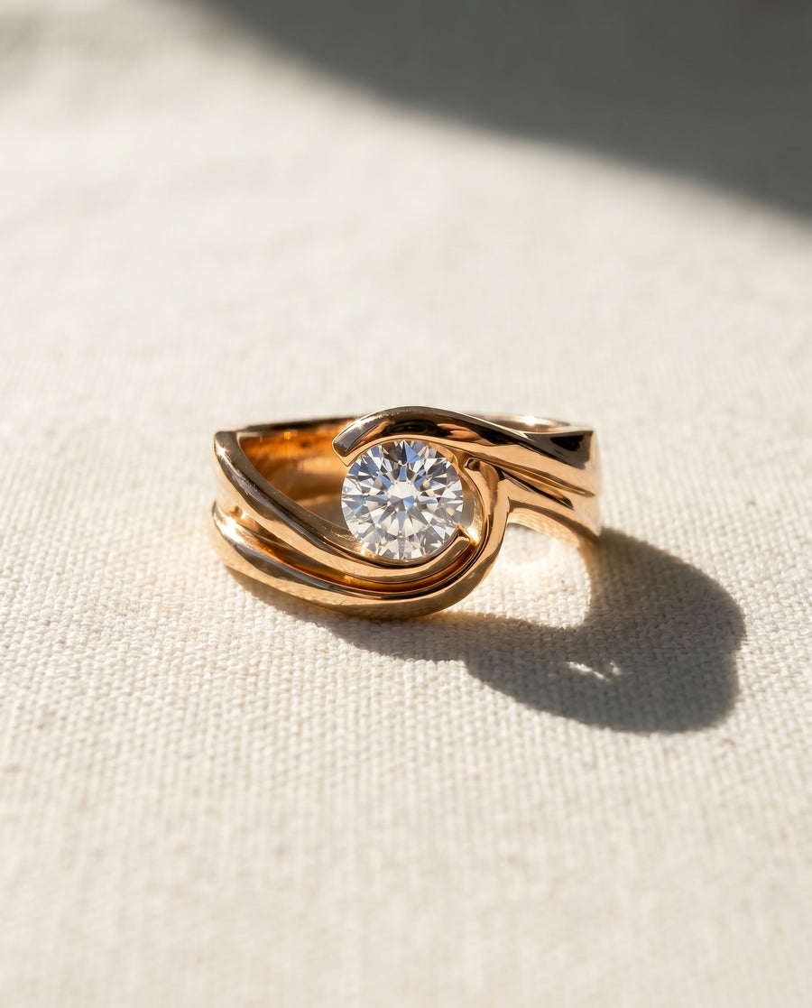 Yellow gold flat twist engagement ring with a round diamond.