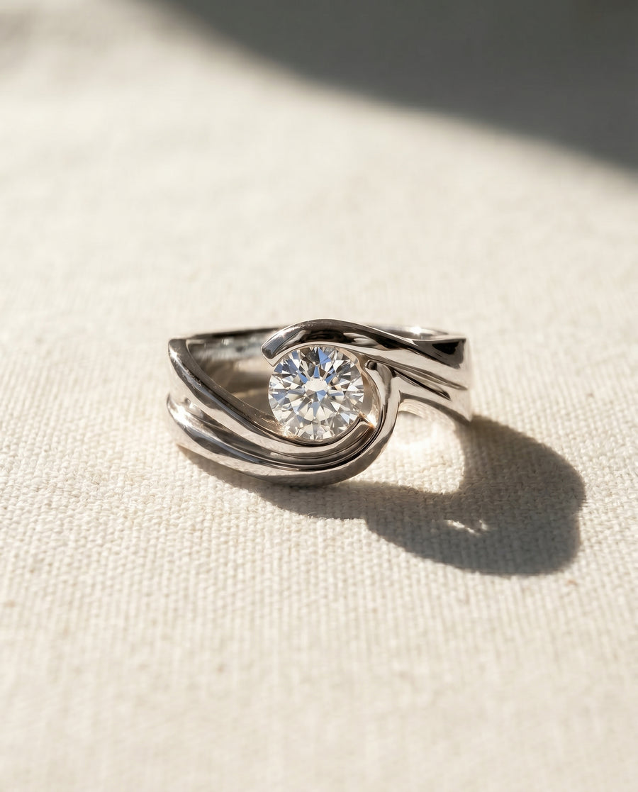 White gold flat twist engagement ring with a round diamond.