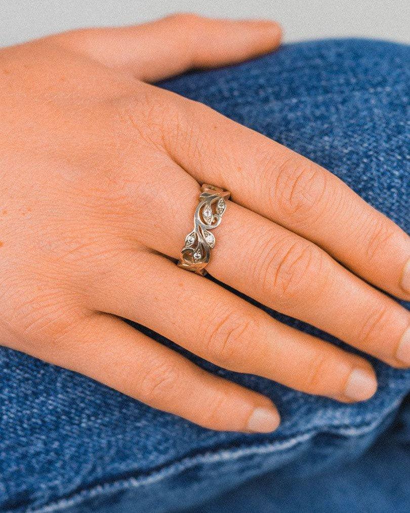 Floral diamond eternity ring with organic design worn on hand, close-up