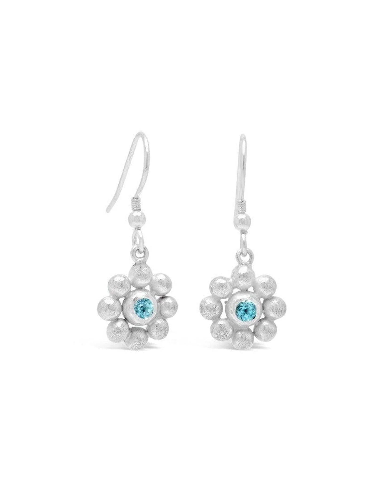 Silver drop earrings featuring a textured flower design with a central pale blue sky blue topaz gemstone.