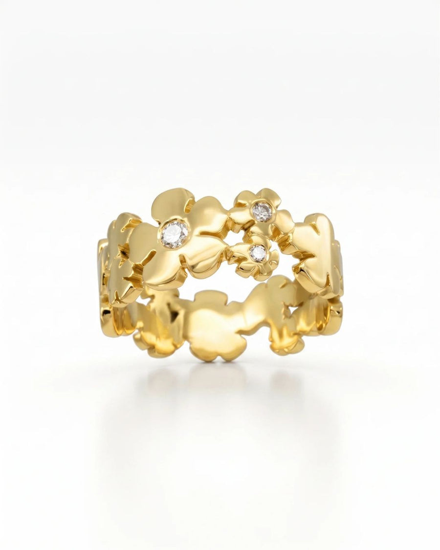 Gold flower eternity ring with three round diamonds.