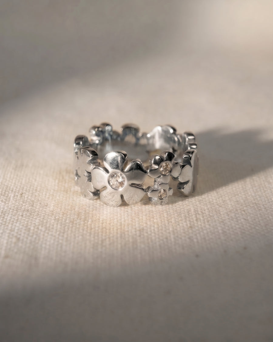 9ct white gold flower eternity ring with small round diamonds.