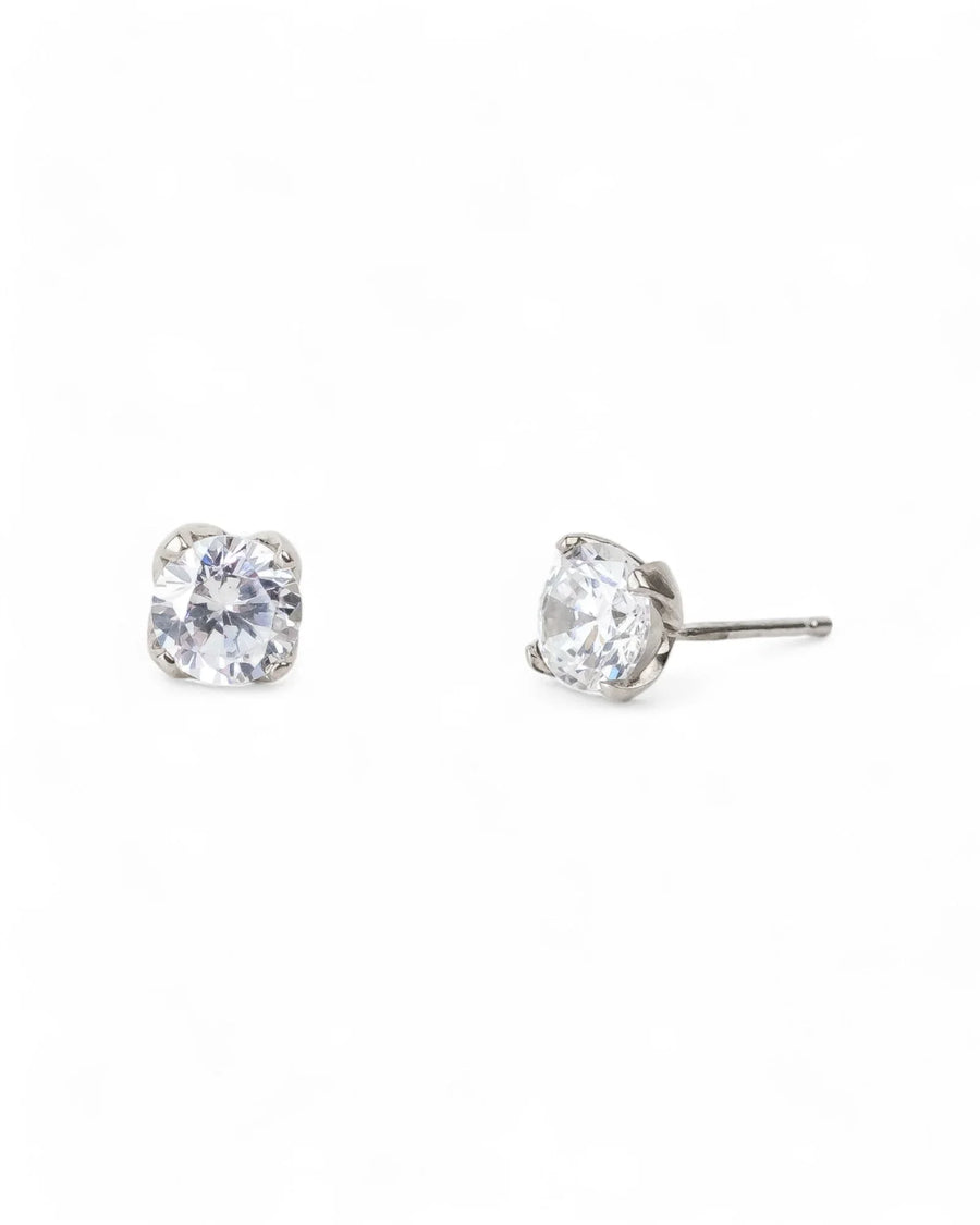 Silver four claw diamond stud earrings with clear gemstones.