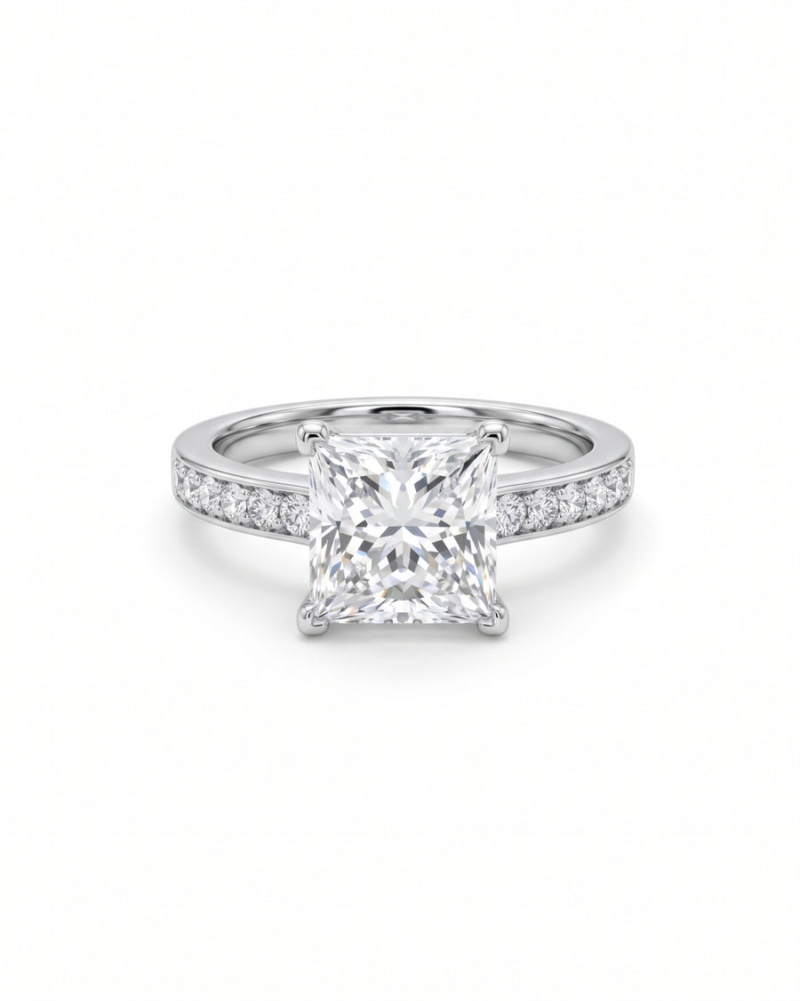 Princess cut diamond engagement ring in platinum with a four-claw setting and pavé diamond band.