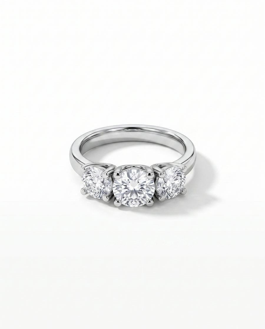 Platinum trilogy ring featuring three round brilliant cut diamonds in a four-claw setting.