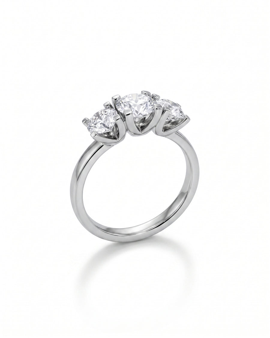 Platinum trilogy ring featuring three round brilliant cut diamonds in a four claw V setting.