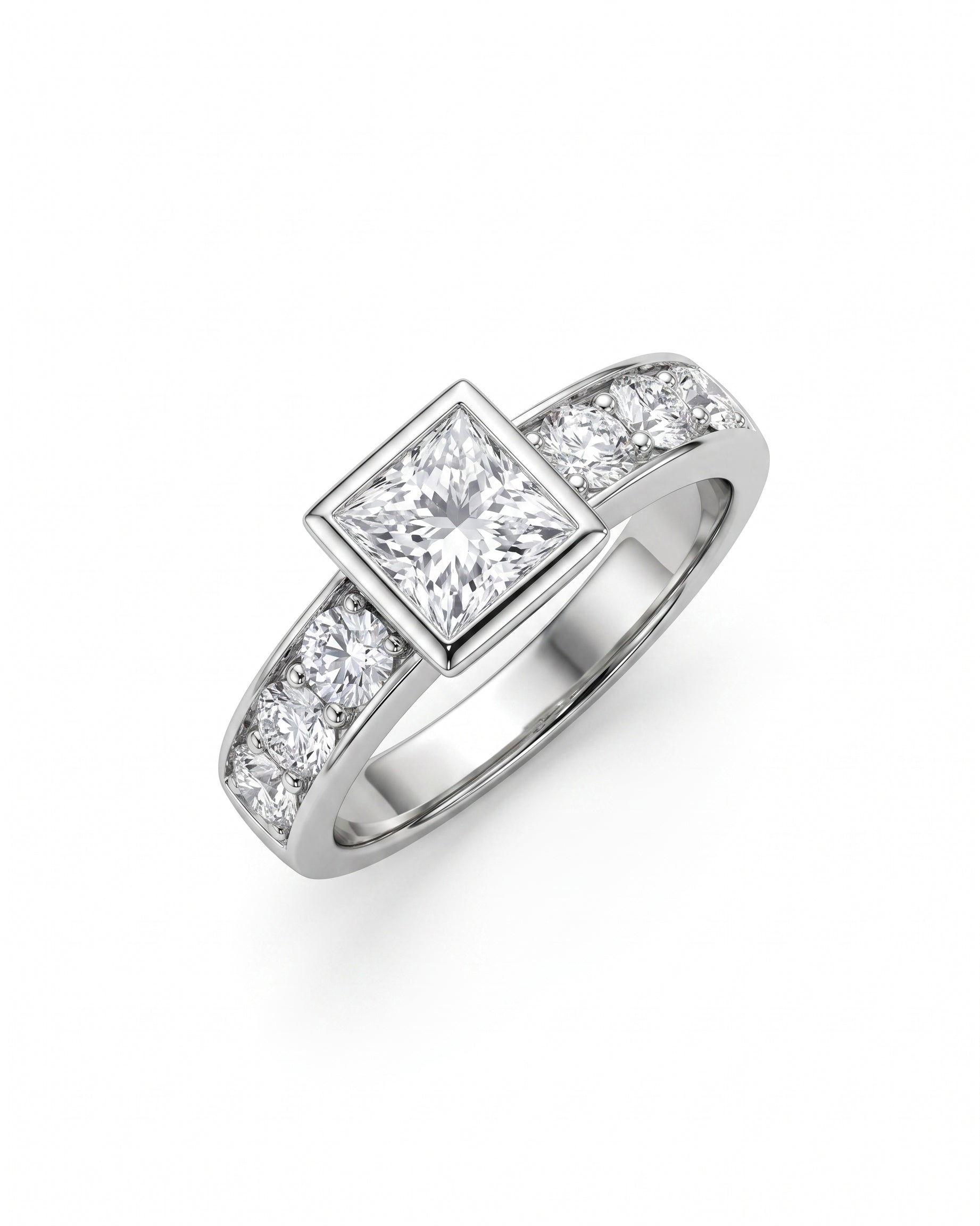White gold engagement ring with a princess cut diamond in a bezel setting and round side diamonds.