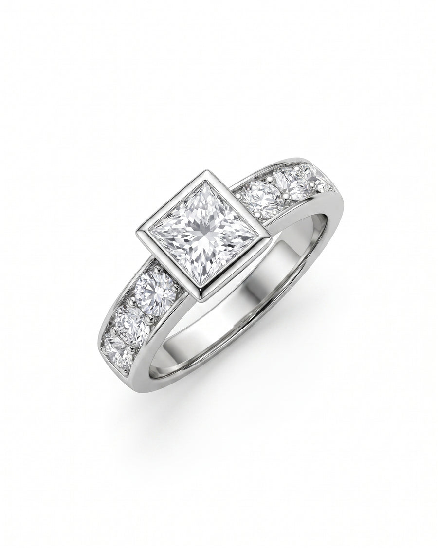 White gold engagement ring with a princess cut diamond in a bezel setting and round side diamonds.