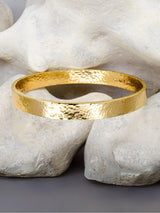 solid 9ct gold bangle on stone background