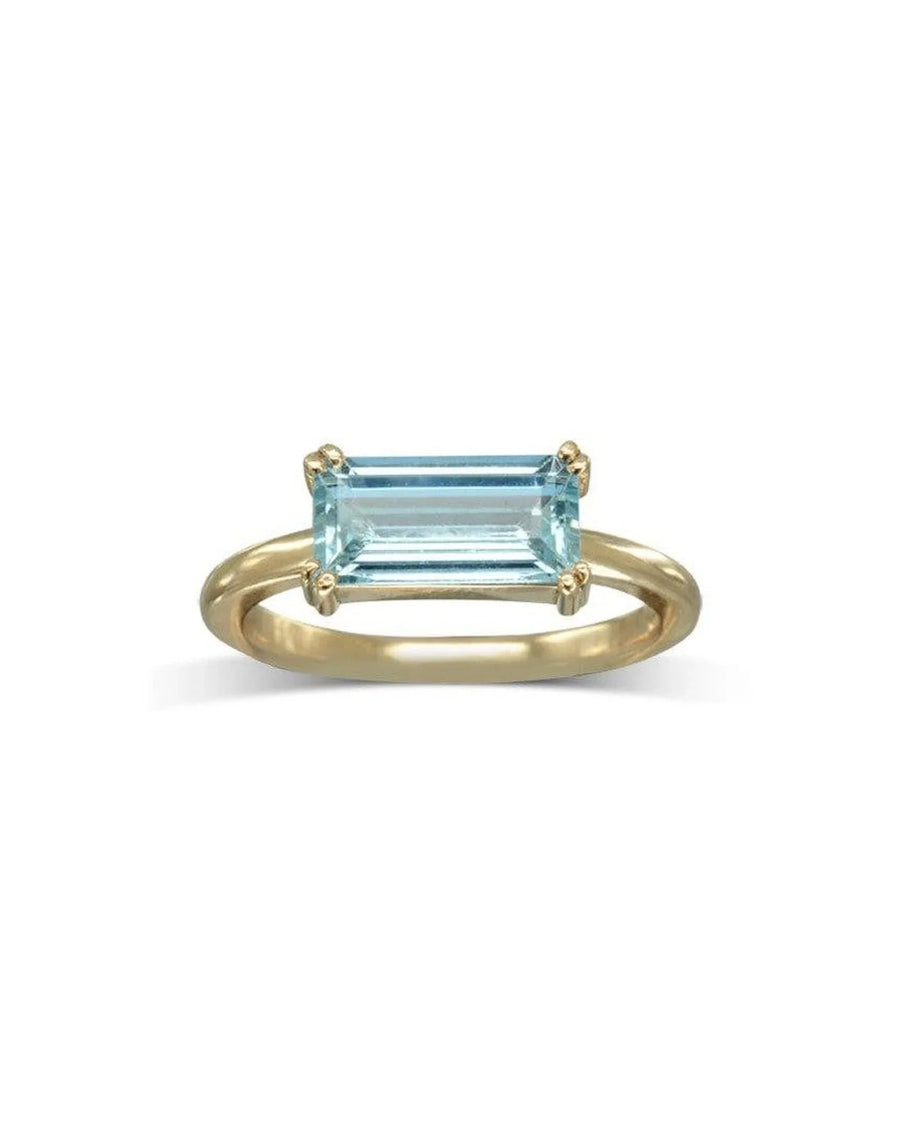 Gold ring with a rectangular light blue gemstone.