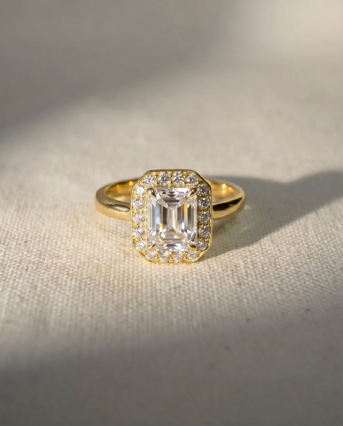 Emerald cut lab grown diamond engagement ring with a halo setting in 18ct yellow gold.