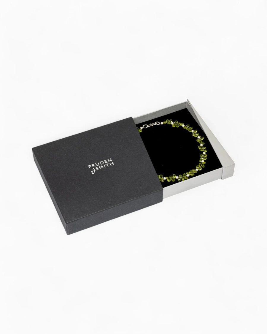 Teardrop green gemstone necklace in a black gift box on a white background