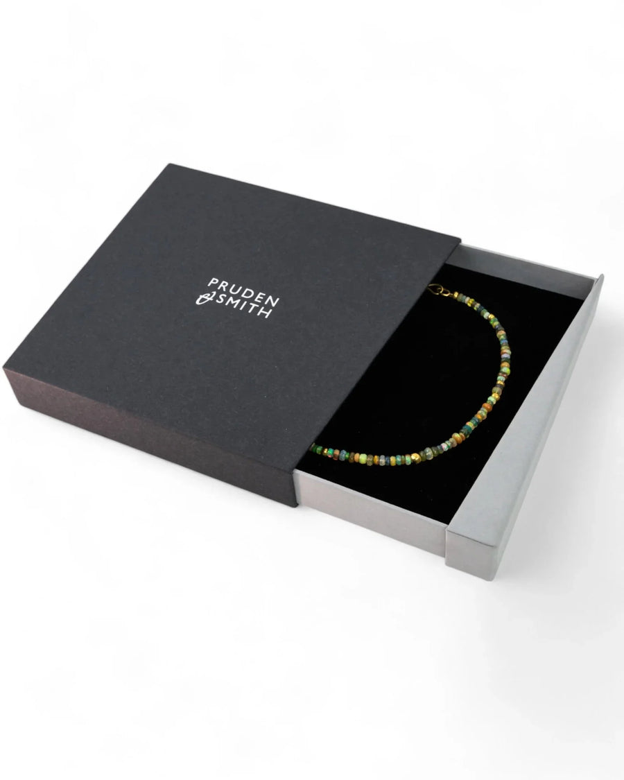 Opal beaded gold necklace with natural stones displayed in a black gift box