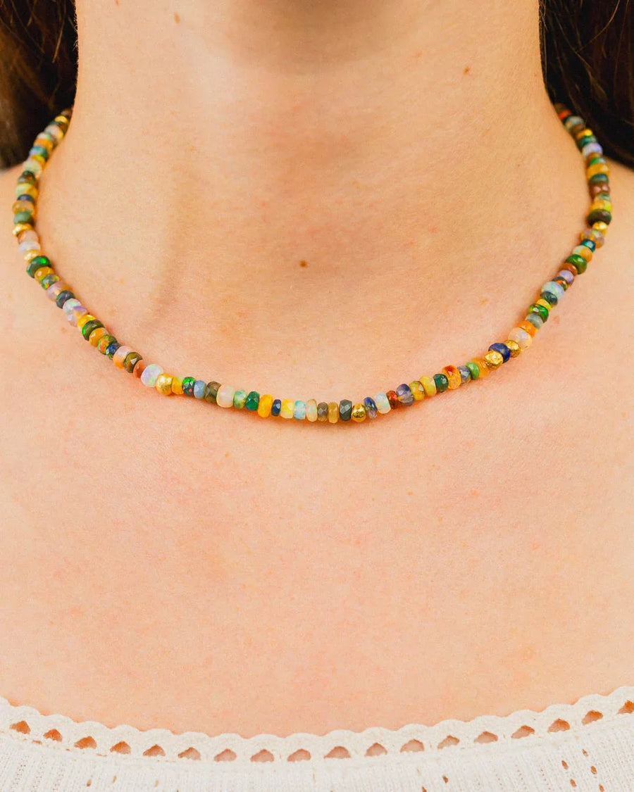 Colorful opal bead necklace with gold accents on a woman's neck