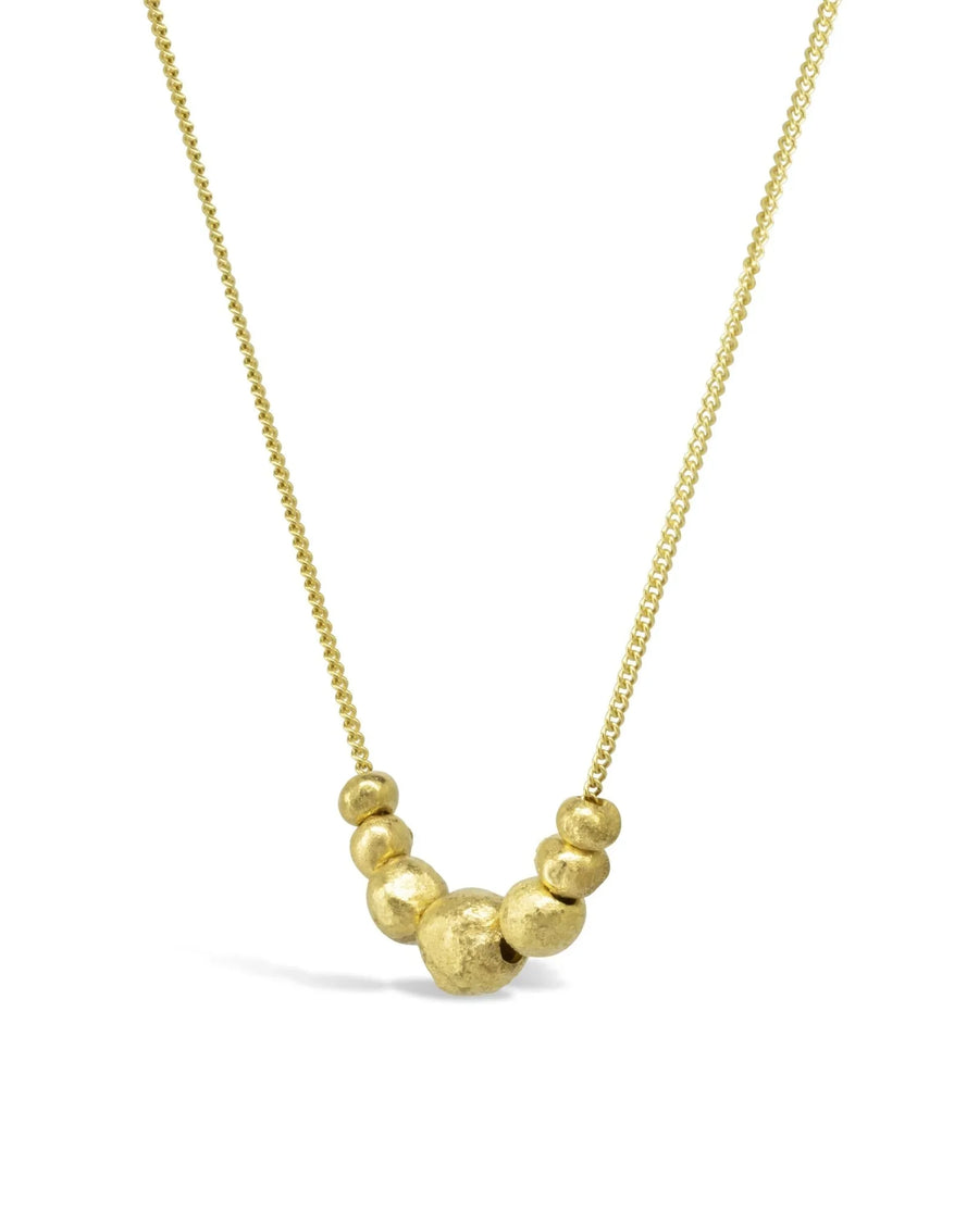 Gold necklace with organic nugget beads and textured pendant on a fine chain