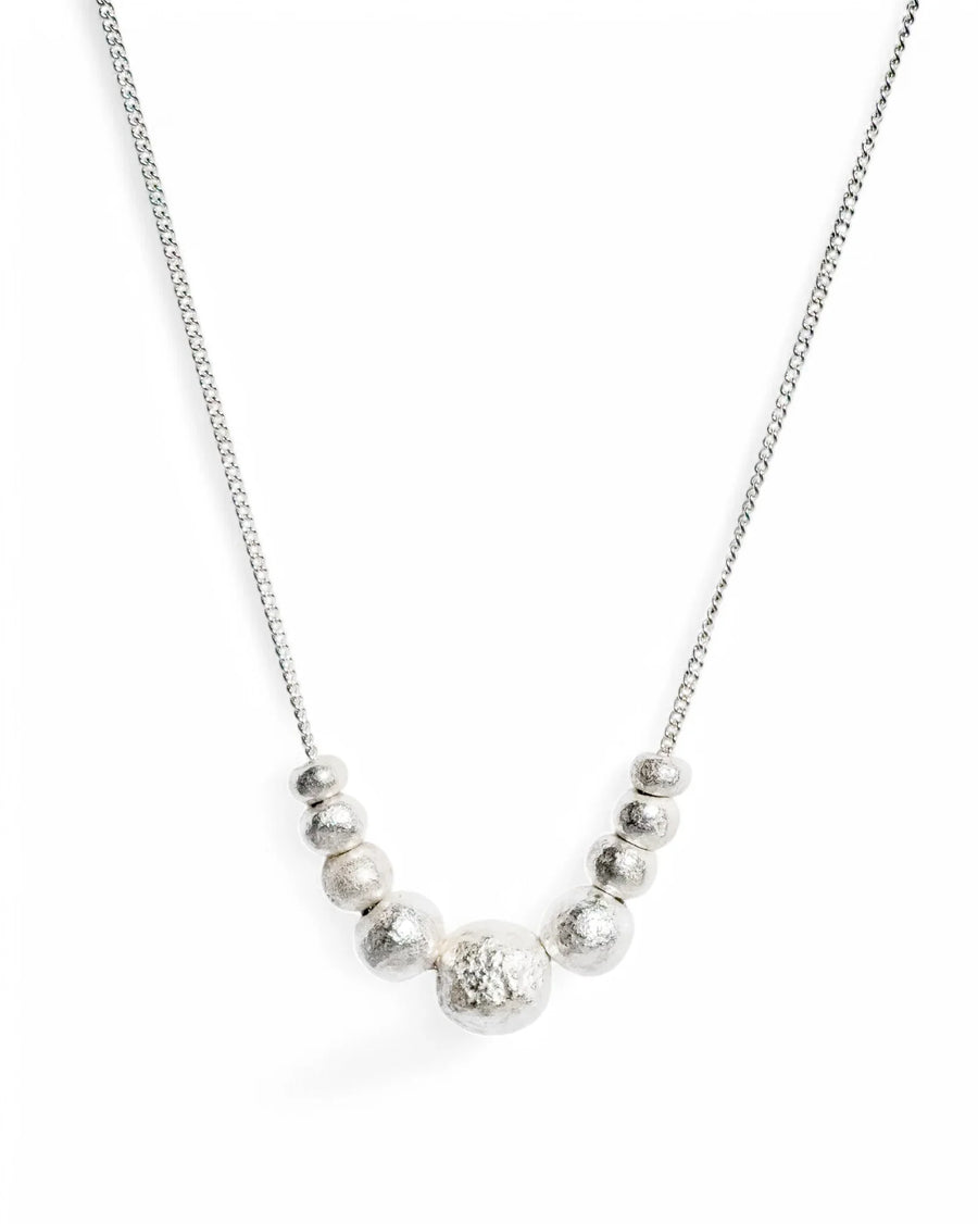 Handmade silver necklace with textured organic bead design on a fine chain