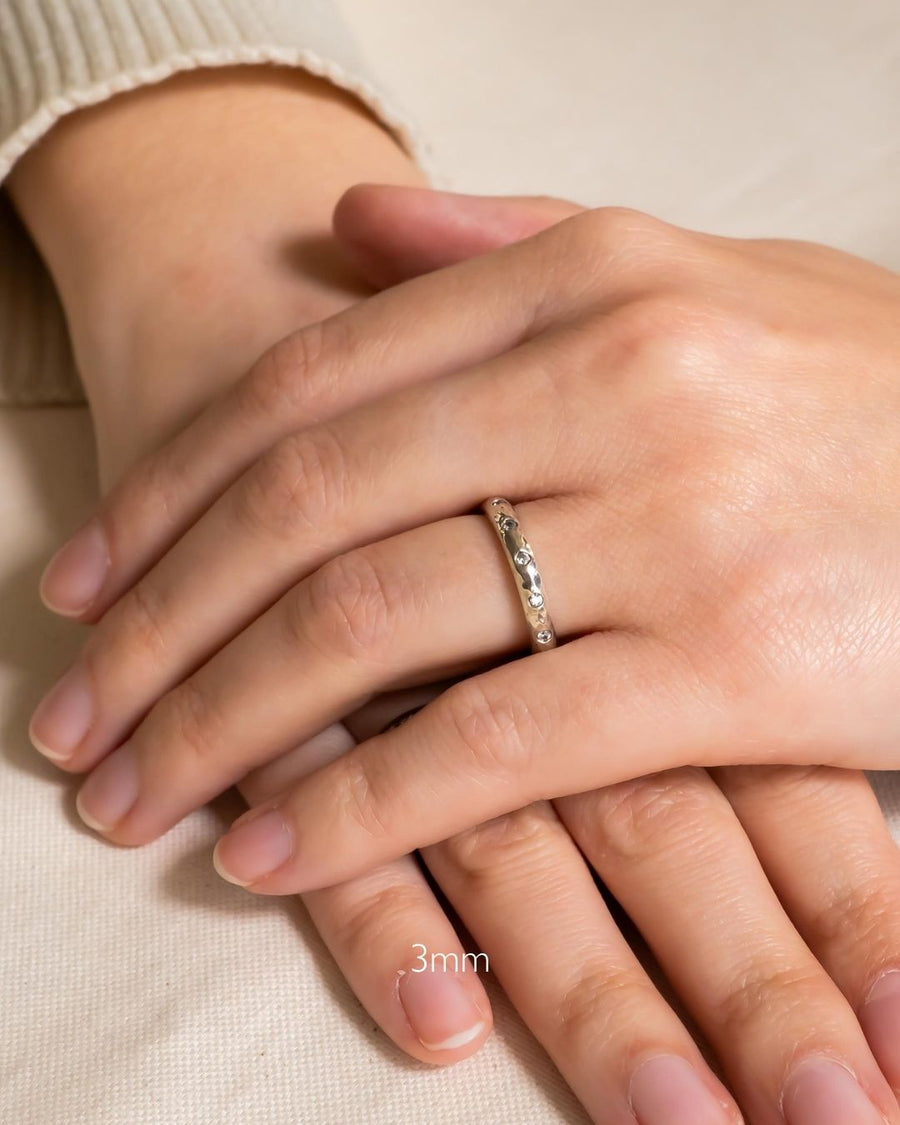 Silver hammered diamond ring on a hand, 3mm wide.