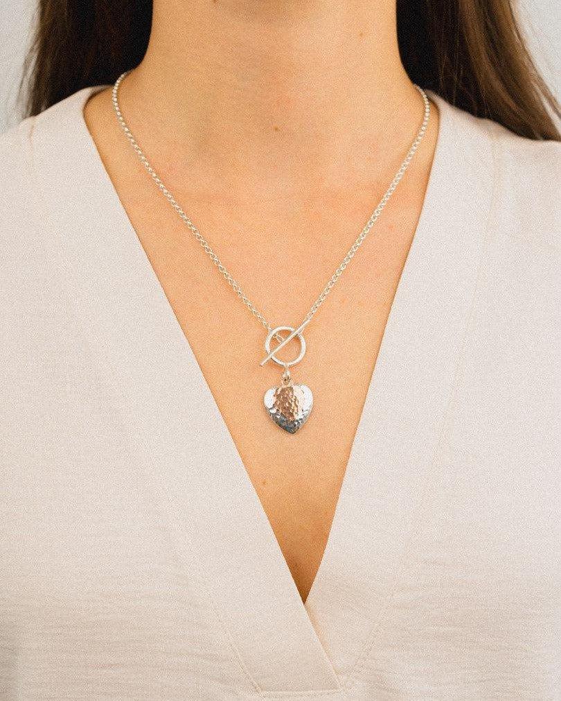 Hammered double heart silver and rose gold pendant necklace on woman