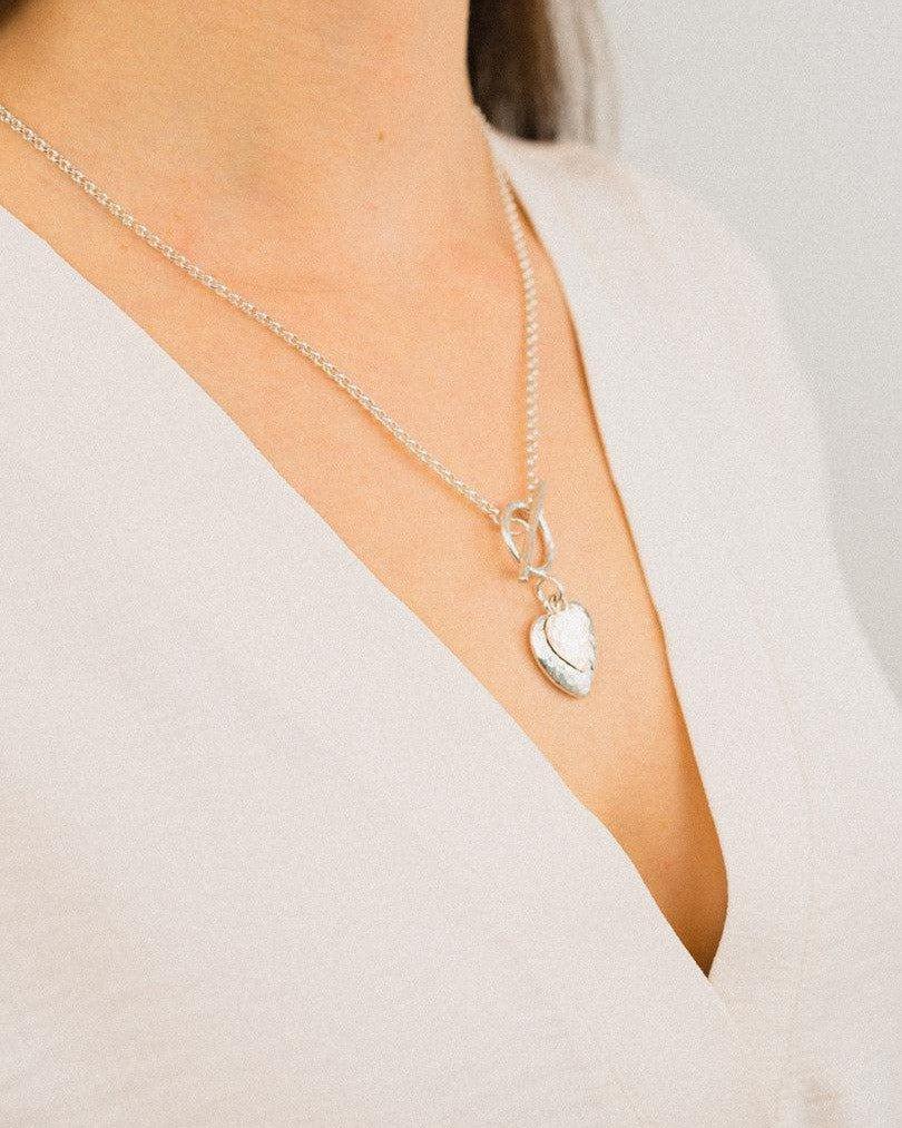 Hammered double heart silver and rose gold pendant necklace on woman