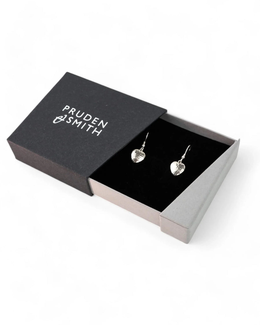 Silver hammered heart drop earrings in a black gift box.