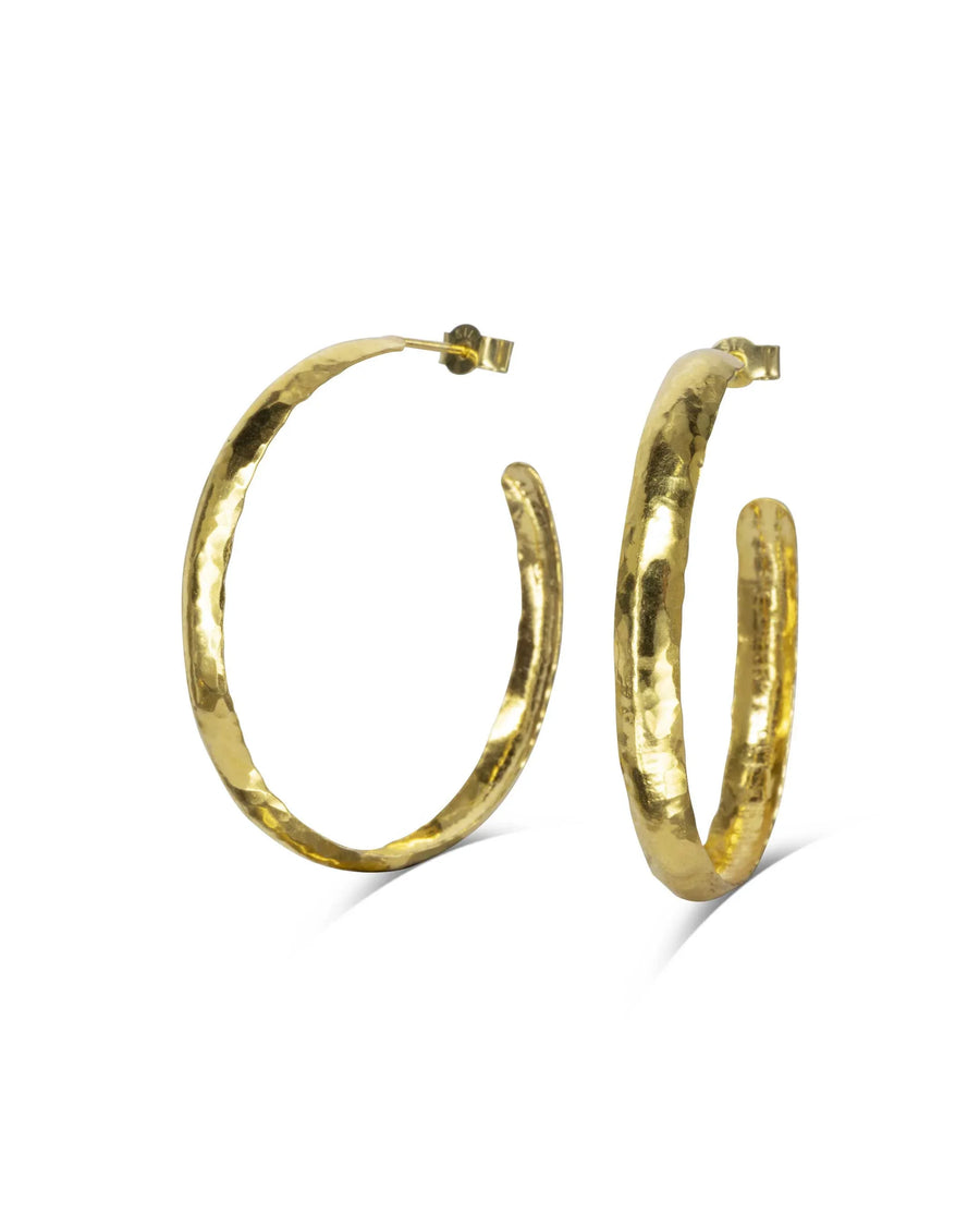 Handmade gold narrow hoop earrings with hammered texture on white background