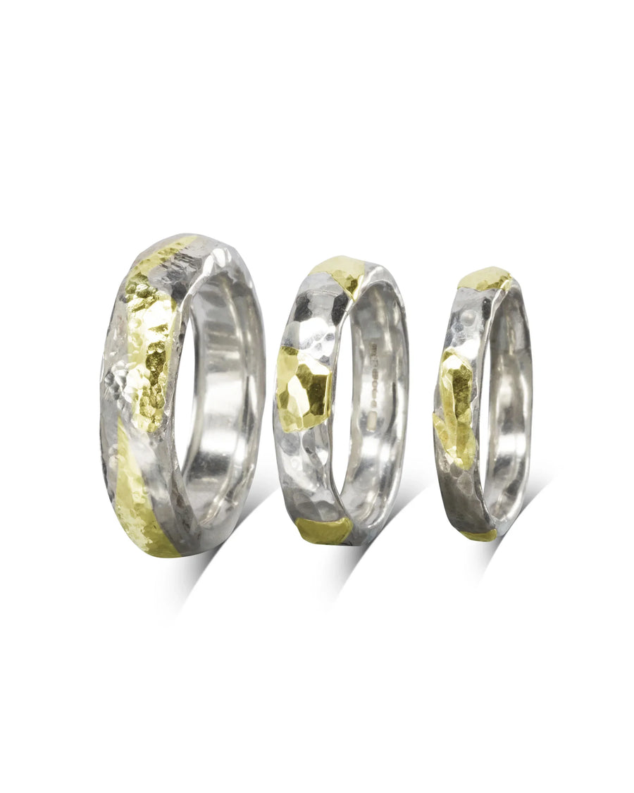 Three hammered silver and 9ct yellow gold court rings of varying widths.