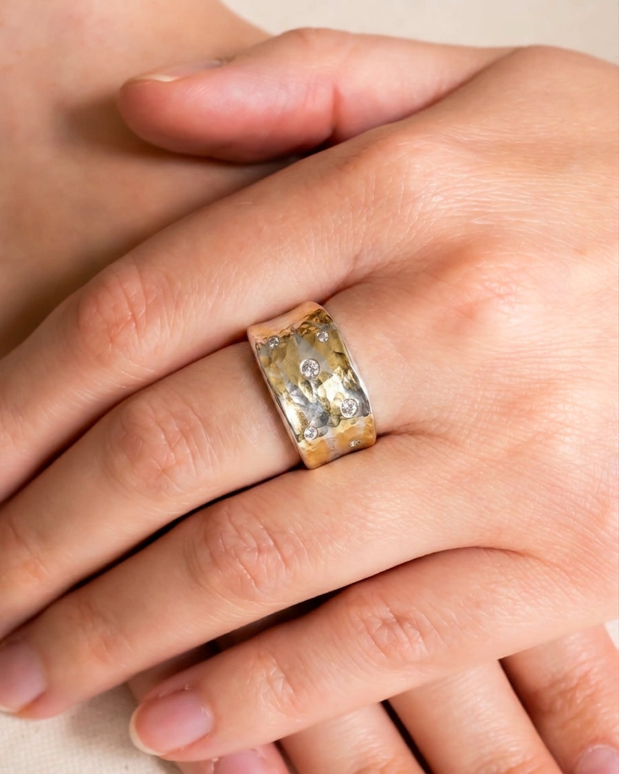 Wide hammered mixed metal ring with scattered diamonds.