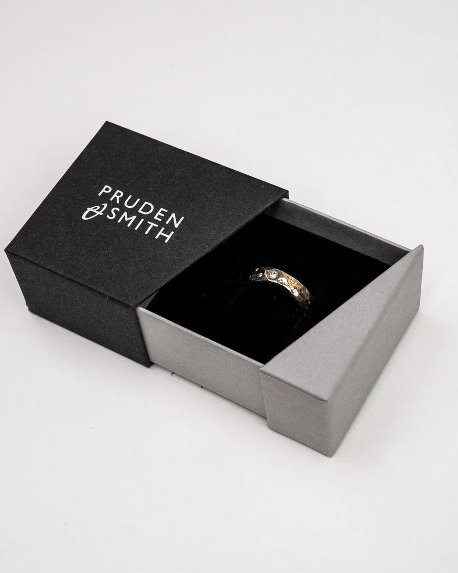 Hammered mixed metal gold diamond ring in a black and gray box.