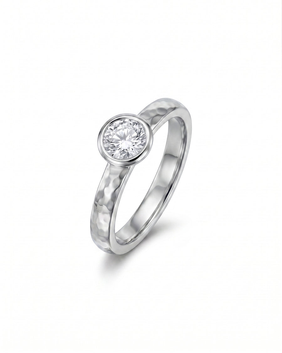 Hammered platinum ring with a round brilliant cut diamond.