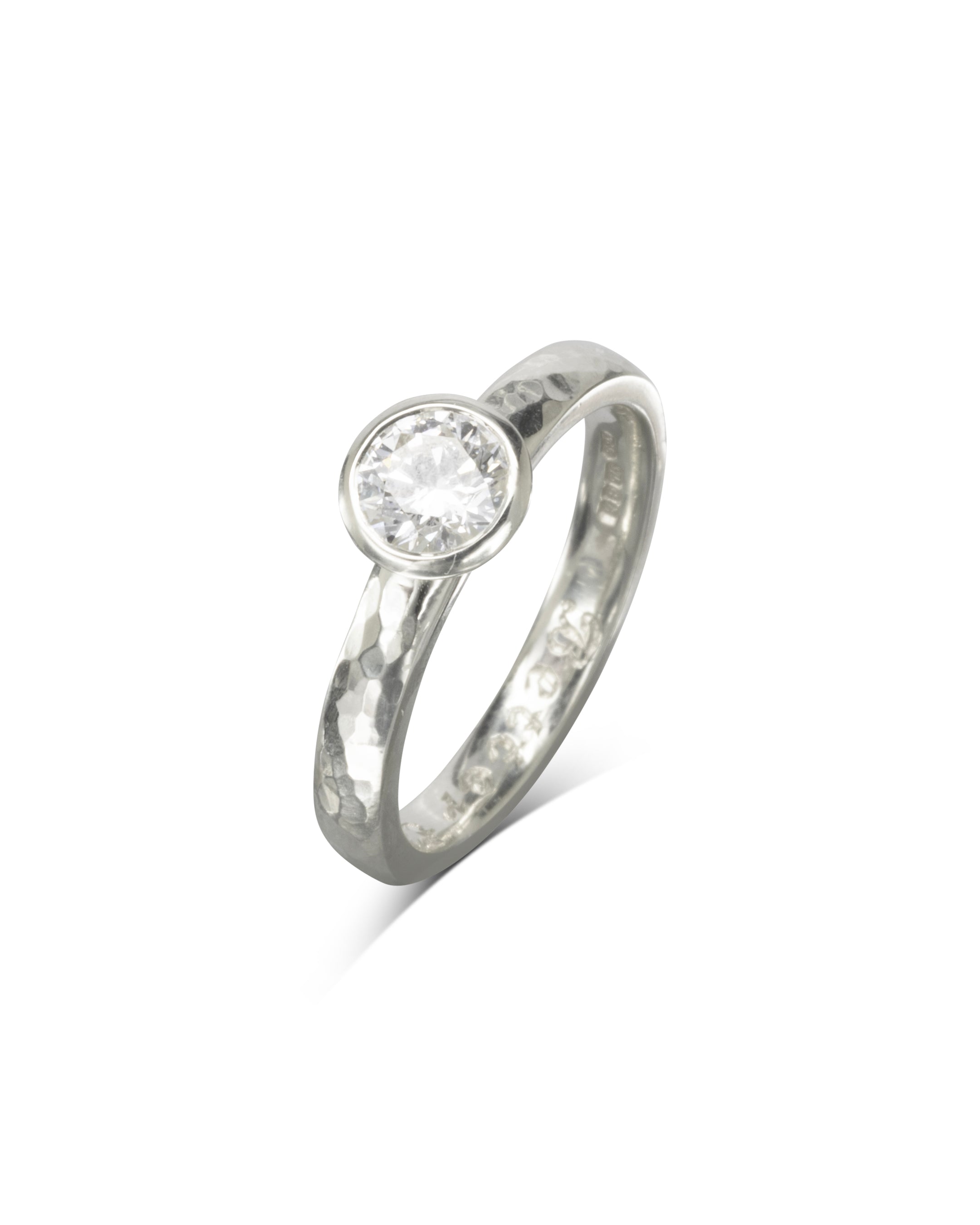Hammered platinum ring with a round brilliant cut diamond.