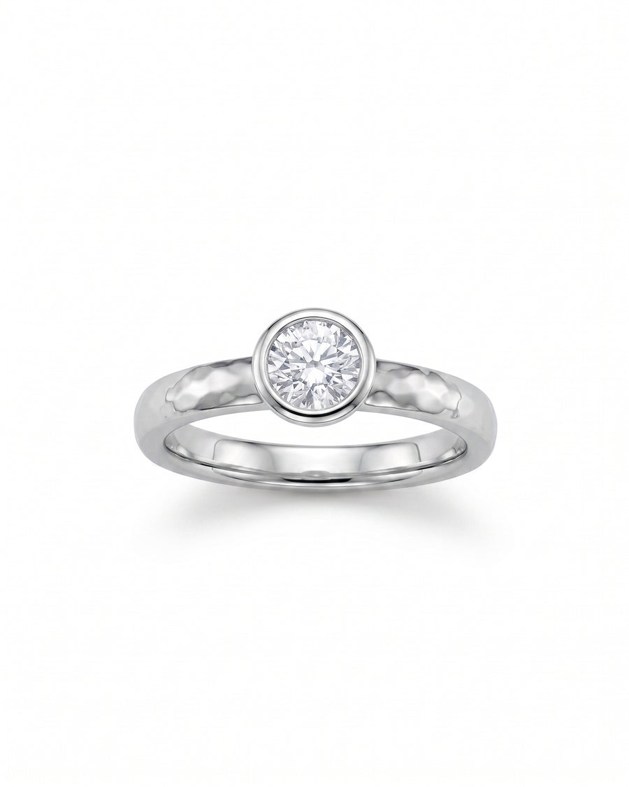 Hammered platinum ring with a round brilliant cut diamond.