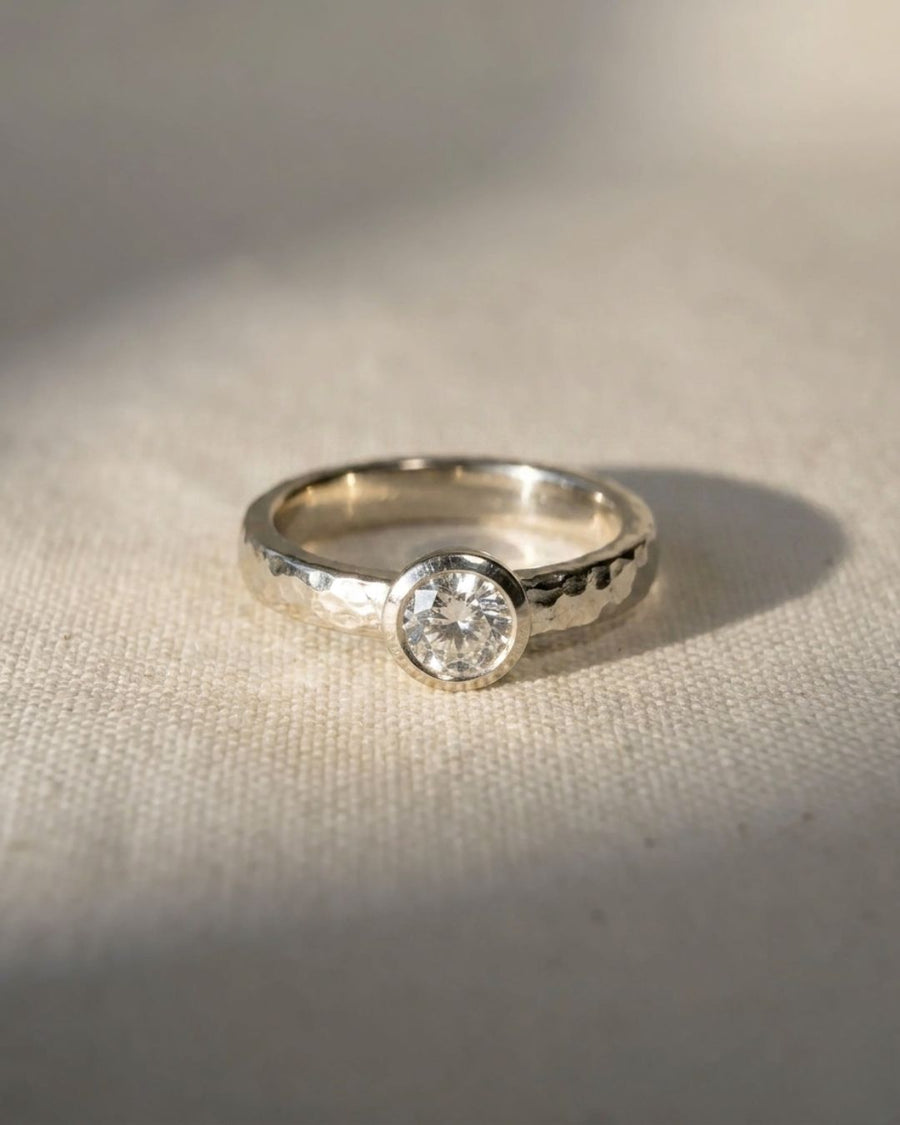 Hammered white gold ring with a round brilliant cut diamond.