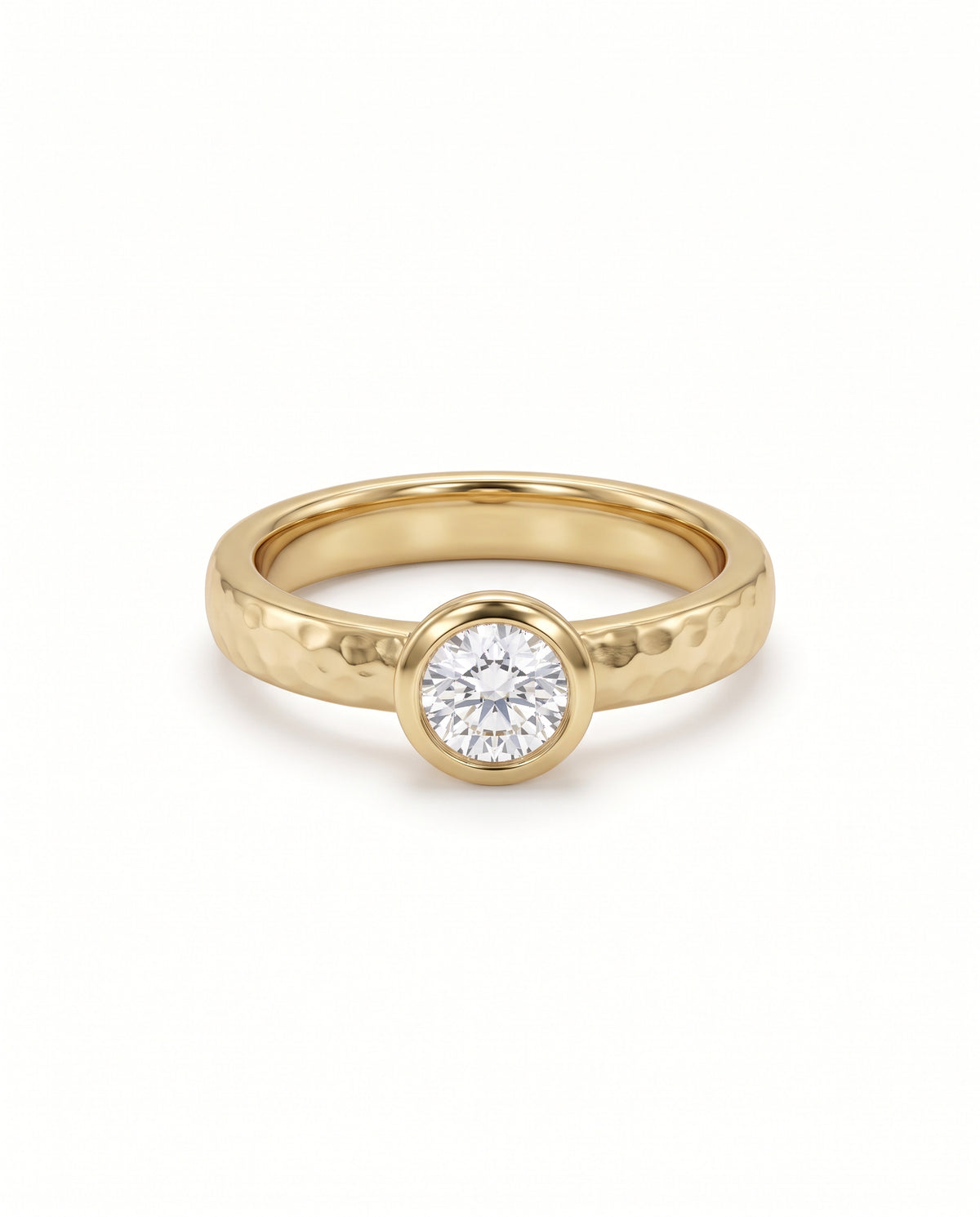 9ct yellow gold ring with a hammered finish and a round brilliant cut diamond in a bezel setting.