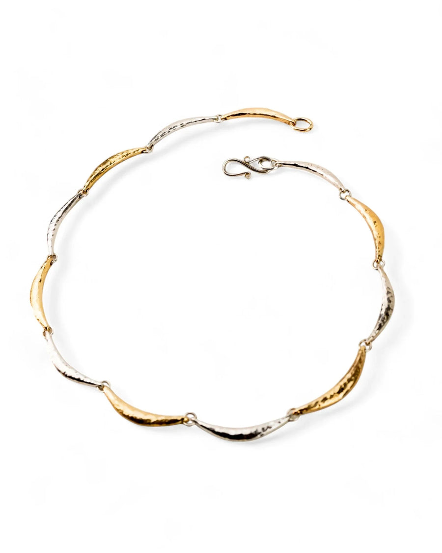 Hammered silver and gold crescent link necklace with organic texture on white background