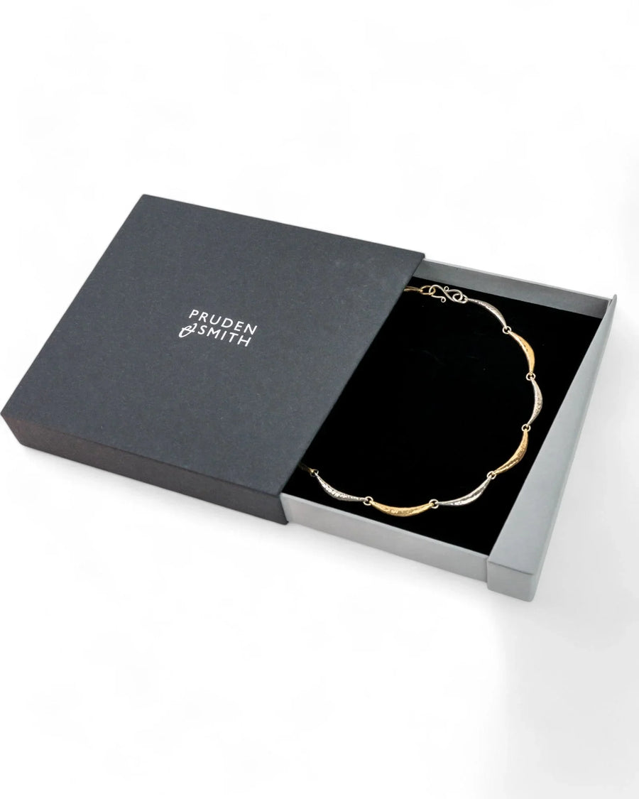 Hammered silver and gold crescent necklace in a gift box, artisanal luxury jewellery