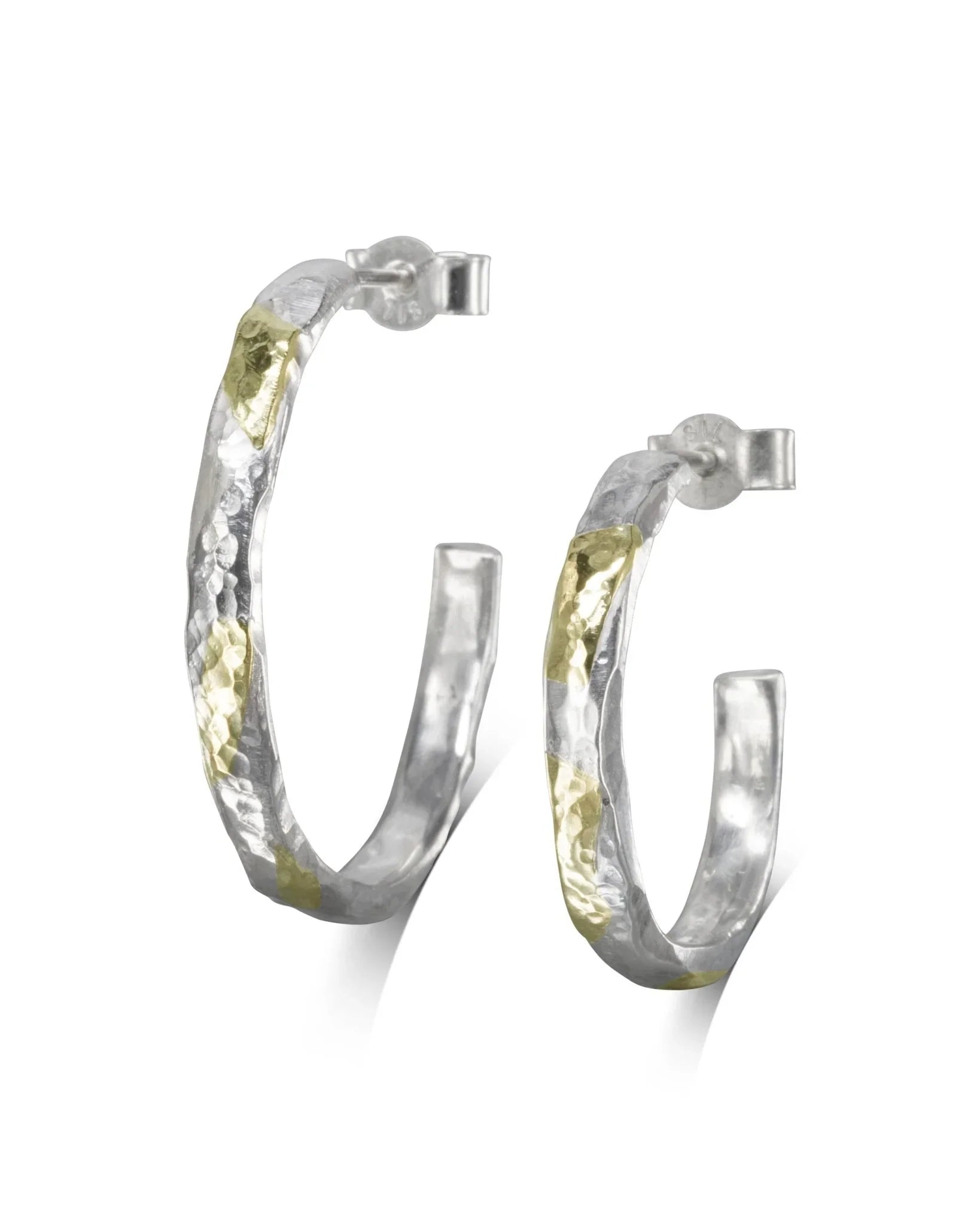 Hammered silver and gold hoop earrings.