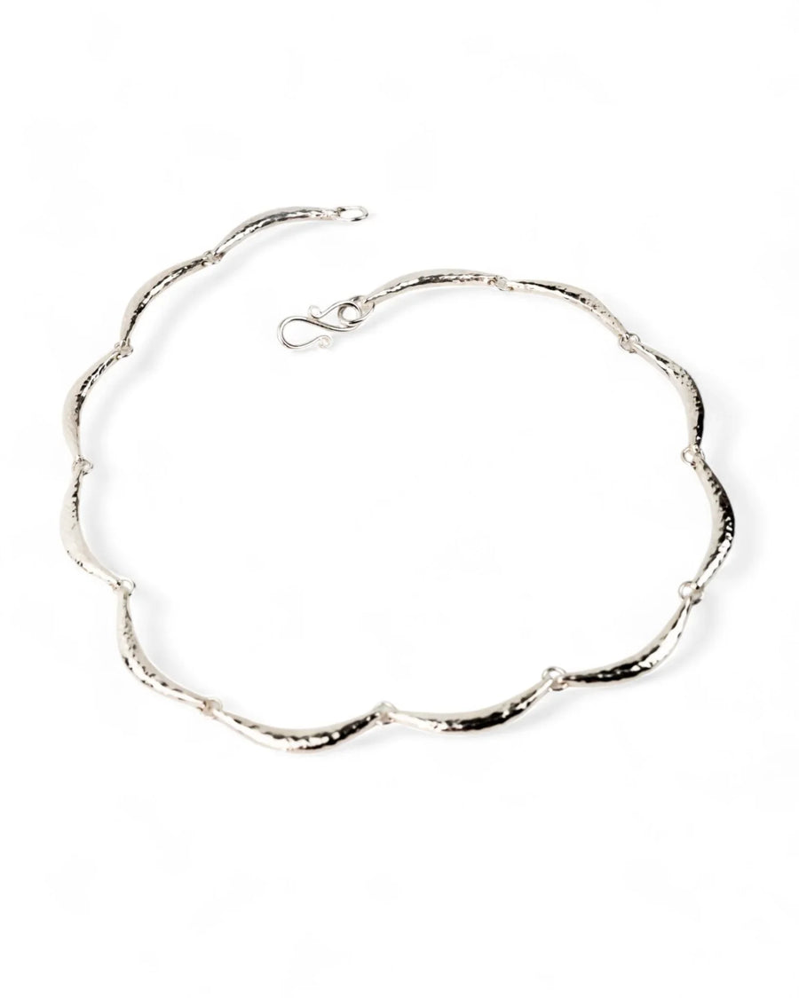 Hammered silver crescent necklace with organic, textured links on a white background