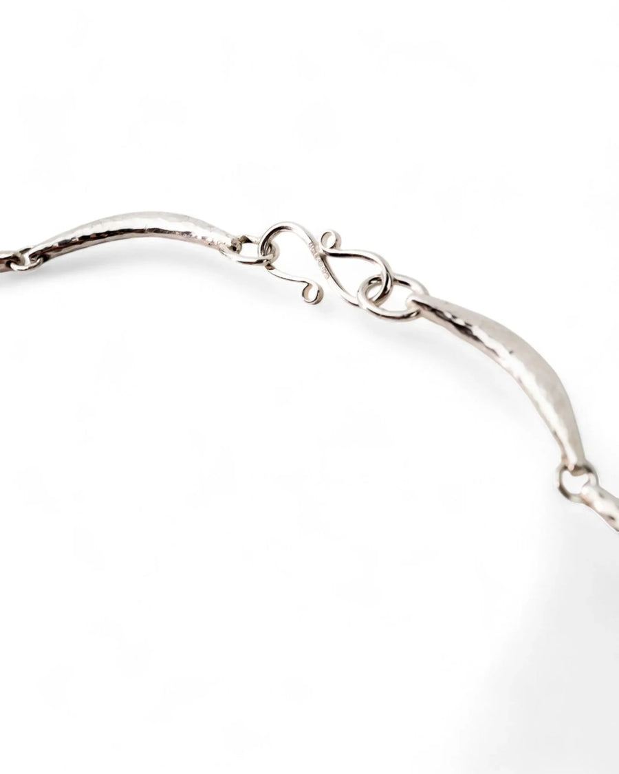 Hammered silver crescent necklace with textured finish and curved hook clasp