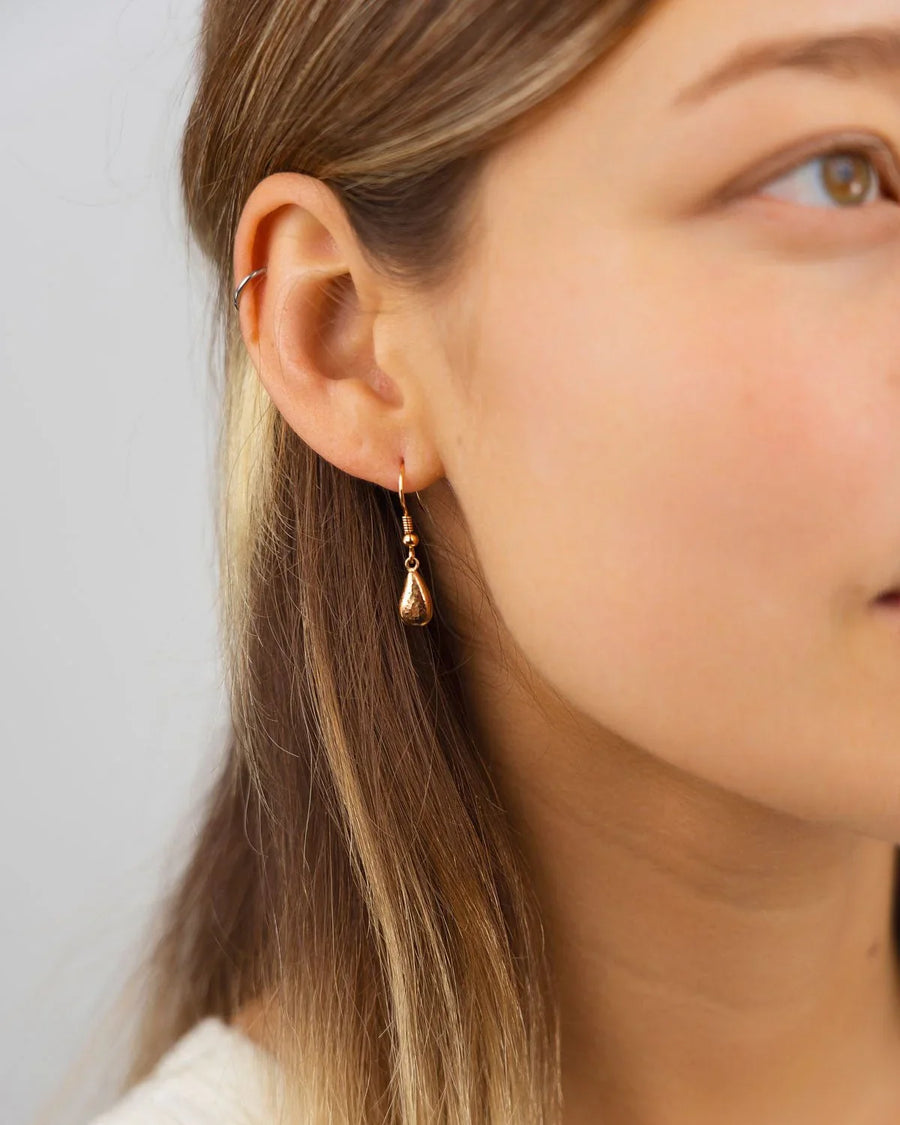 Hammered teardrop 9ct yellow gold drop earring on ear, handmade jewellery