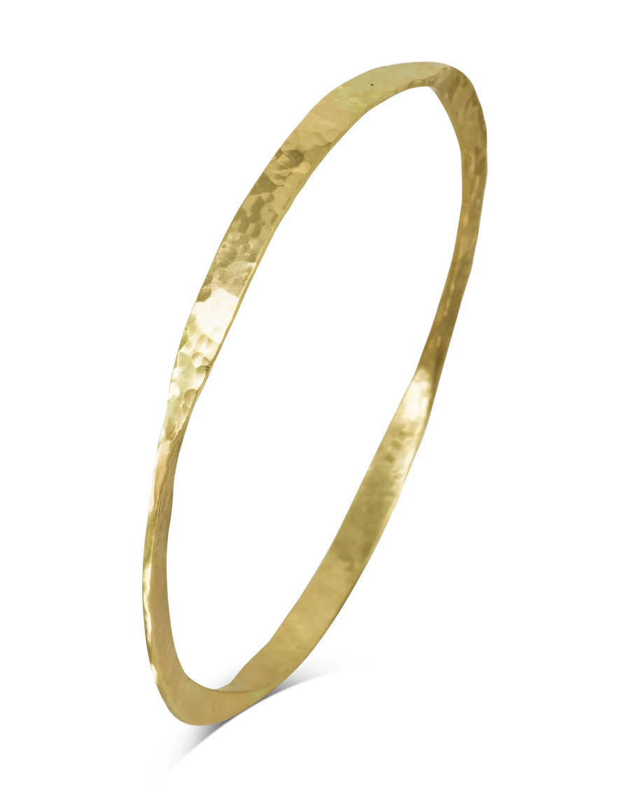 Handmade twisted gold bangle with hammered texture on white background