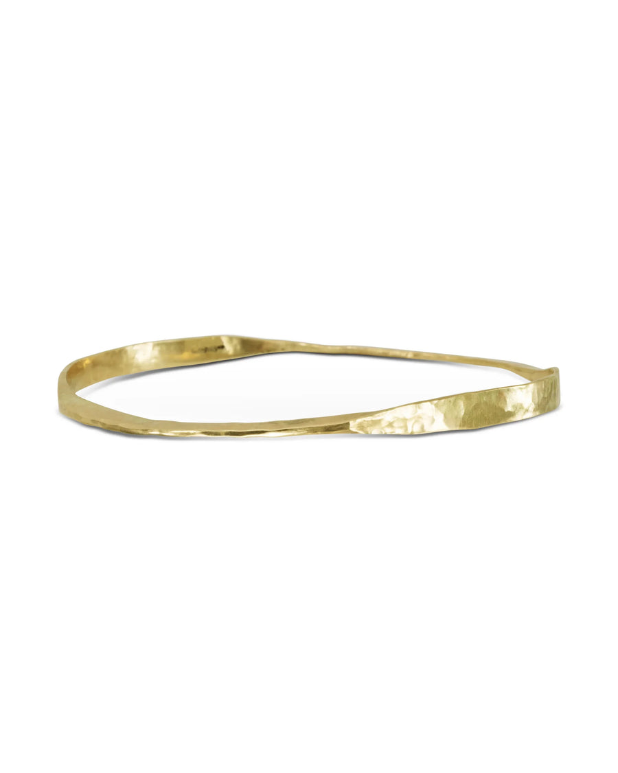 Handmade gold bangle with hammered finish and organic twisted shape on white background